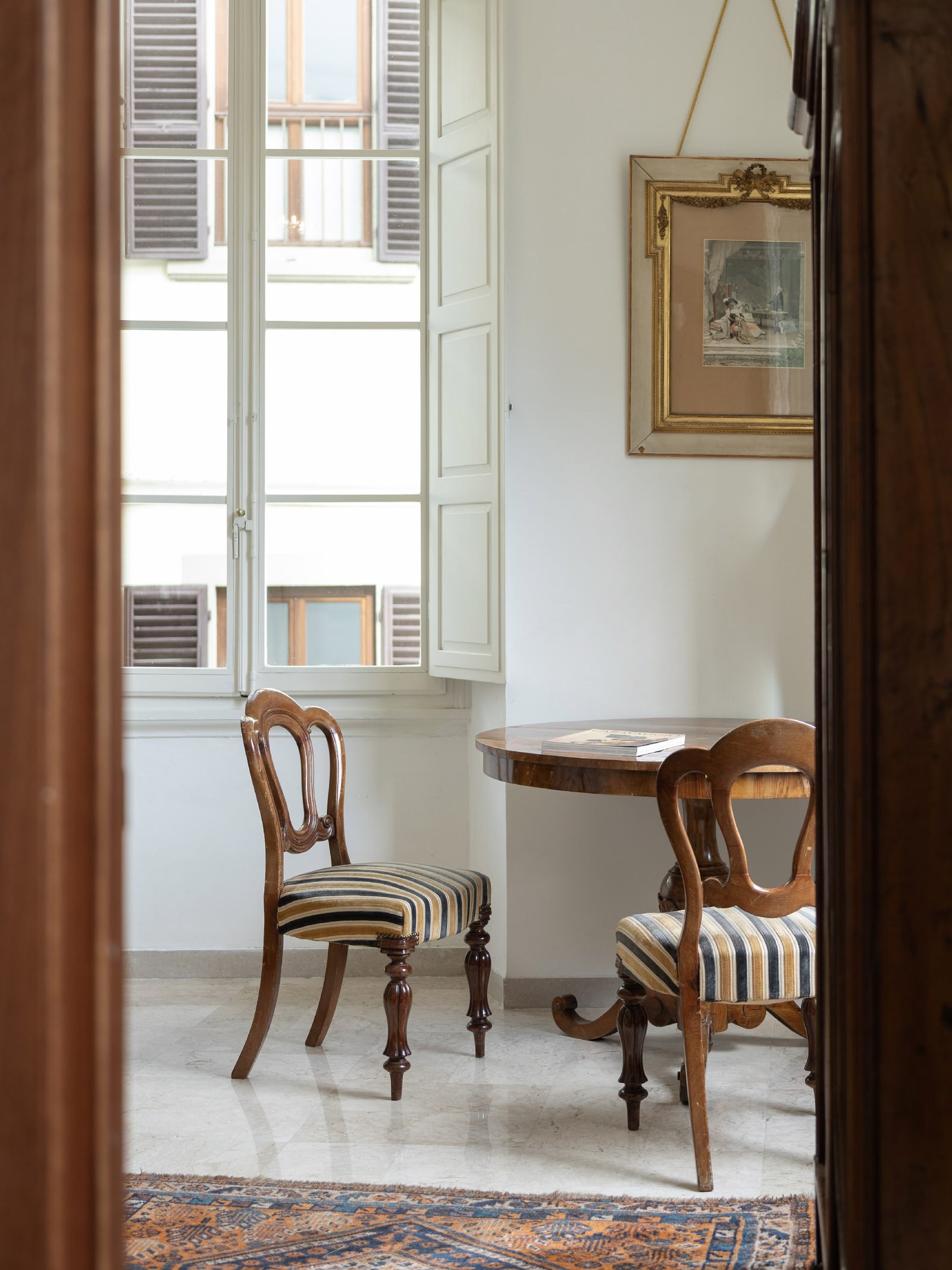 Table and chairs by a window inside the palazzo