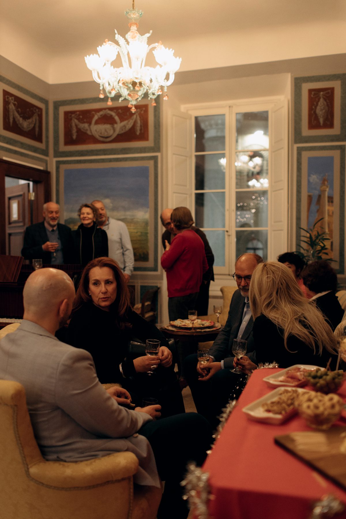Guests gathered in the frescoed salotto